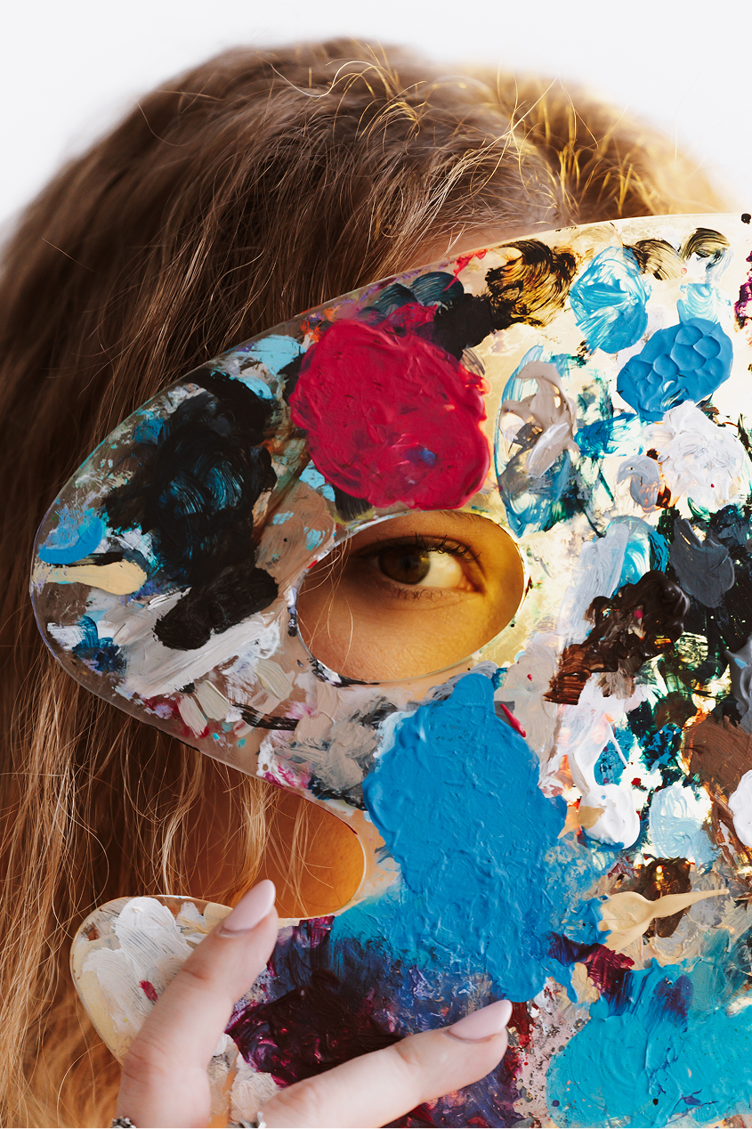 Nina holding a paint palette in front of her face